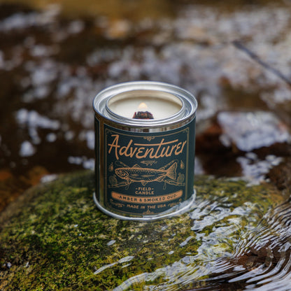 Amber & smokey scented soy candle in a sleek container, showcasing its warm, inviting glow.