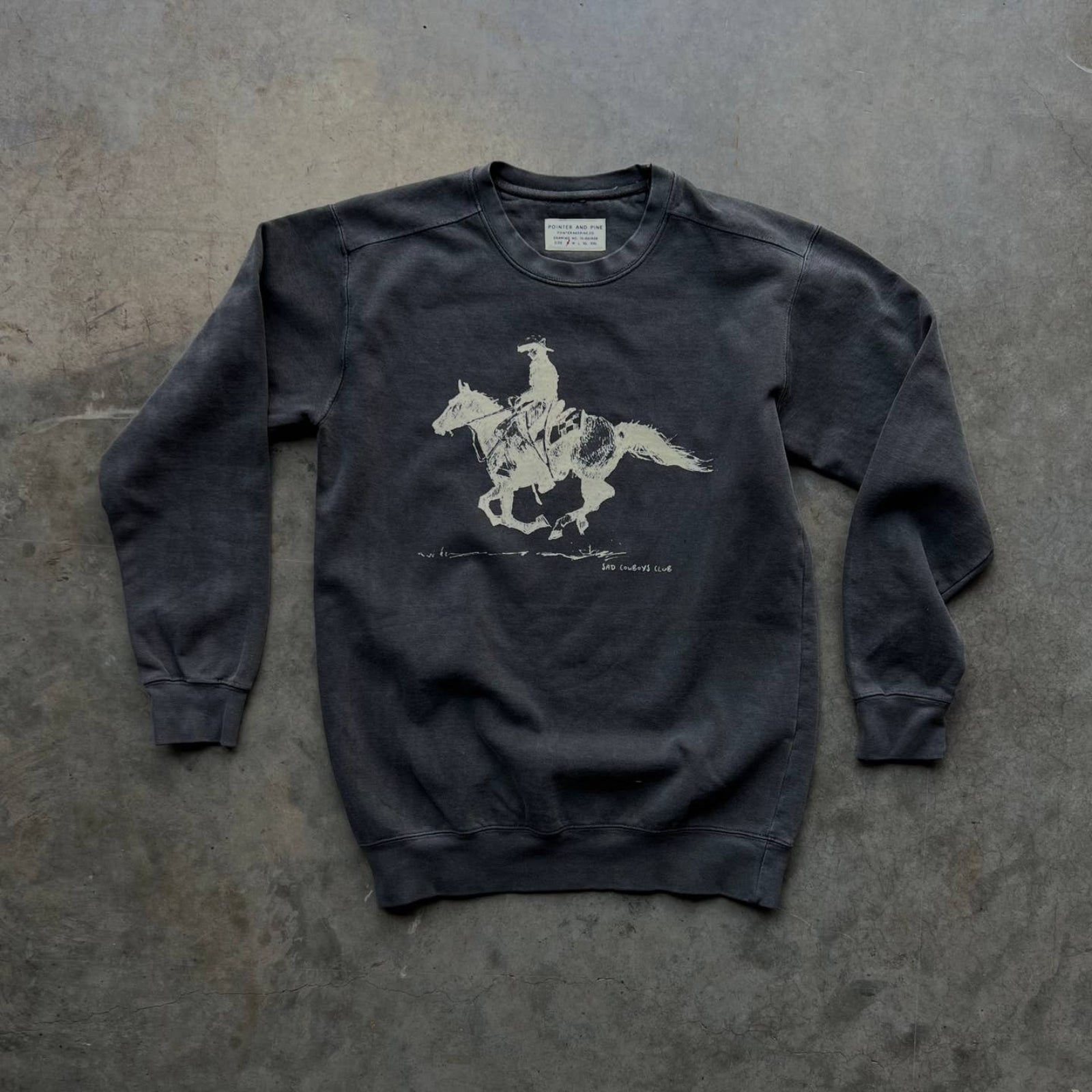 Pointer and Pine charcoal crewneck sweatshirt featuring a cowboy riding a horse, designed for comfort and western-inspired style.