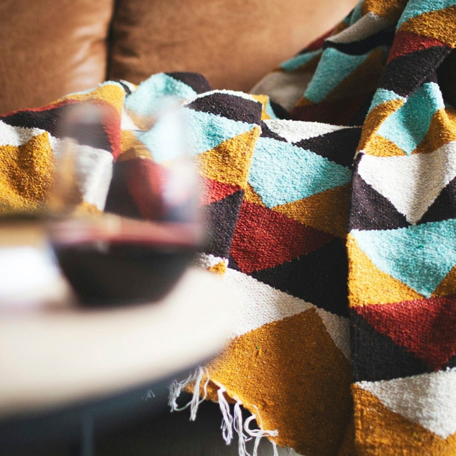 Handwoven throw blanket with intricate patterns, showcasing its cozy texture and warm colors.