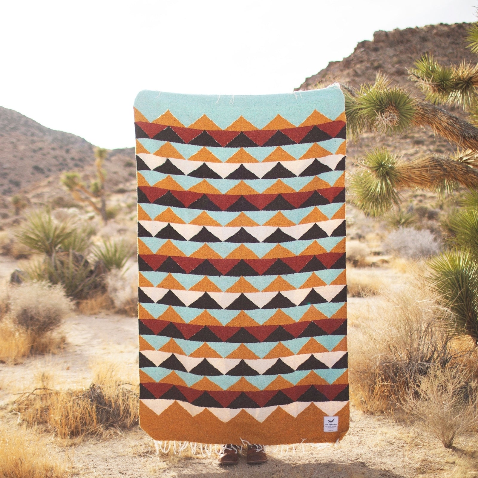 Handwoven throw blanket with intricate patterns, showcasing its cozy texture and warm colors.