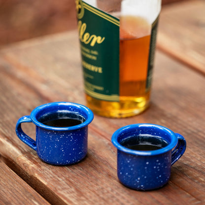 Two rugged mini shot glasses made from durable blue enamel, perfect for outdoor adventures and stylish drink servings.