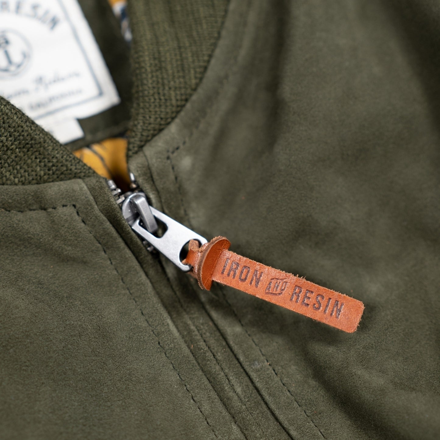 Close up of luxuriously soft goat suede bomber jacket with custom cotton poplin liner, two exterior side welt pockets for warmth, and vintage-inspired details for a classic look.